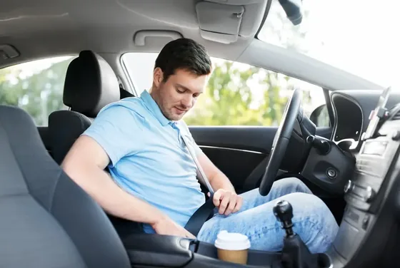 Driver fastening the seat belt in the front seat of a passenger car.