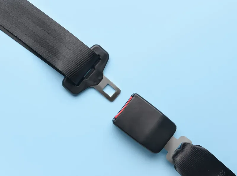 Seat belt webbing with latch plate and buckle laid out against a plain background as a product view.